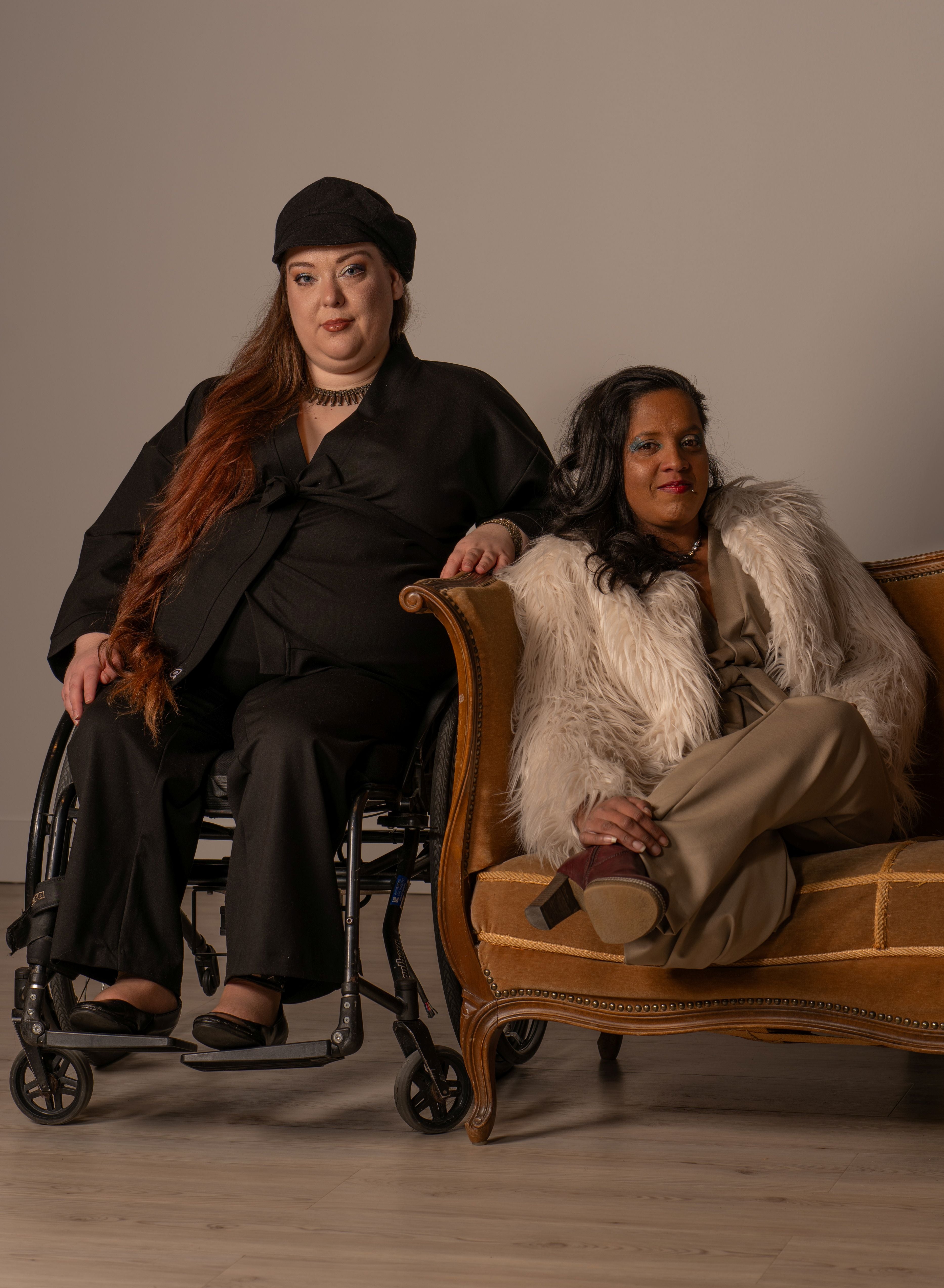 En modell sitter i rullstol och bär en svart kimono och den andra modellen sitter i en soffa bredvid och har en beige kimono.
