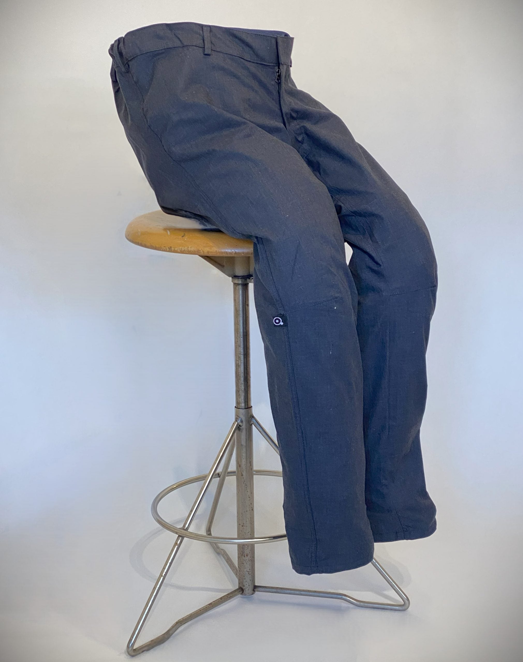 Adaptivt mode. En blå byxa designade för personer som är rullstolsburna i elastiskt bomullstyg som är helt slät dvs utan ficka.